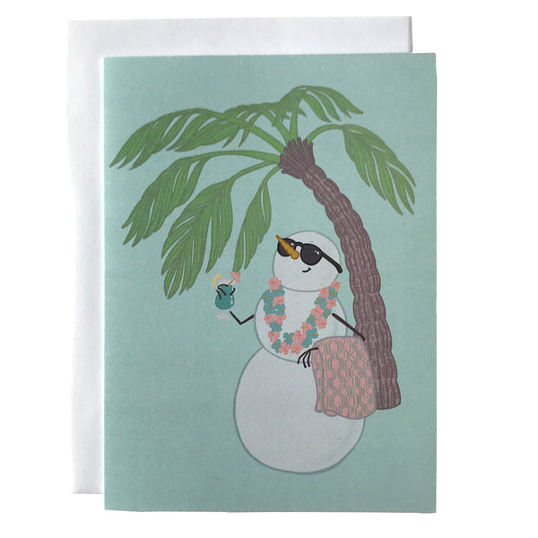 A light blue card shows a snowman holding a towel and a cocktail, wearing a lei and sunglasses. Behind him is a palm tree. The card is against a white envelope on a white background.